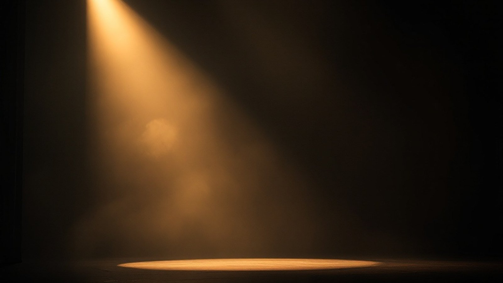 An empty theatre stage lit by a single warm spotlight, haze drifting through the beam