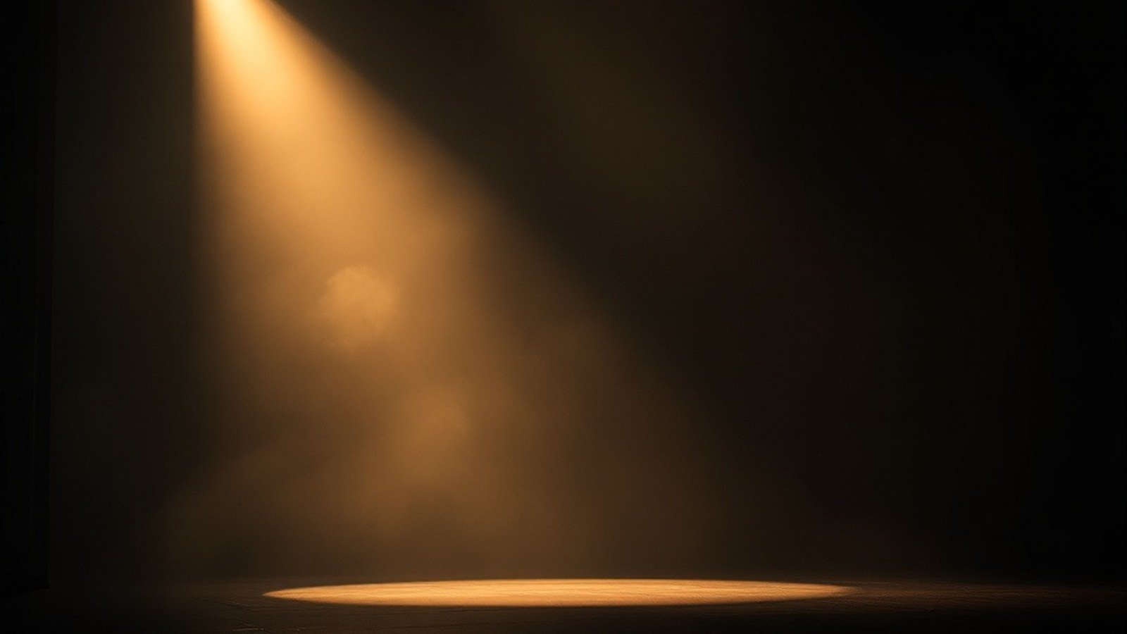 An empty theatre stage lit by a single warm spotlight, haze drifting through the beam